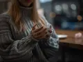 Mięciutki sweter z **lambswool** otula dłonie trzymające kubek. Czy taki materiał **gryzie**? Raczej nie, wygląda na bardzo komfortowy.