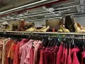 Na półce eleganckie buty i torebki, a poniżej rzędy różowych ubrań. Idealne miejsce, by znaleźć inspirację, jak szyc nowe kreacje.