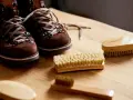 Brązowe zamszowe buty i kilka szczotek do ich czyszczenia. Dowiedz się, jak wyczyścić zamszowe buty, by wyglądały jak nowe.
