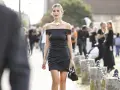 Elegancka mała czarna sukienka z odkrytymi ramionami i drapowanym dołem. Stylowe mała czarna sukienka stylizacje na ulicach miasta.