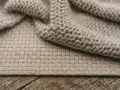 Beżowy materiał, dzianina i splot. Czy bawełna się rozciąga? Zobacz, jak pięknie układa się ten materiał.