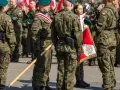Żołnierze w mundurach polowych, zielonych beretach i z biało-czerwonymi flagami. To inspiracja, jak się ubrać na przysięgę wojskową.