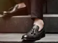 Elegancki garnitur bez skarpetek, czarne mokasyny z frędzlami i ażurowymi zdobieniami.