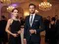 Elegancka para na balu. Ona w czarnej sukni z biżuterią przy dekolcie, on w granatowym garniturze. Świetne dress code przykłady.