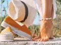 Letnie espadryle w kolorze musztardowym i słomkowy kapelusz. Dowiedz się, jak wyczyścić espadryle, by służyły Ci przez lata.