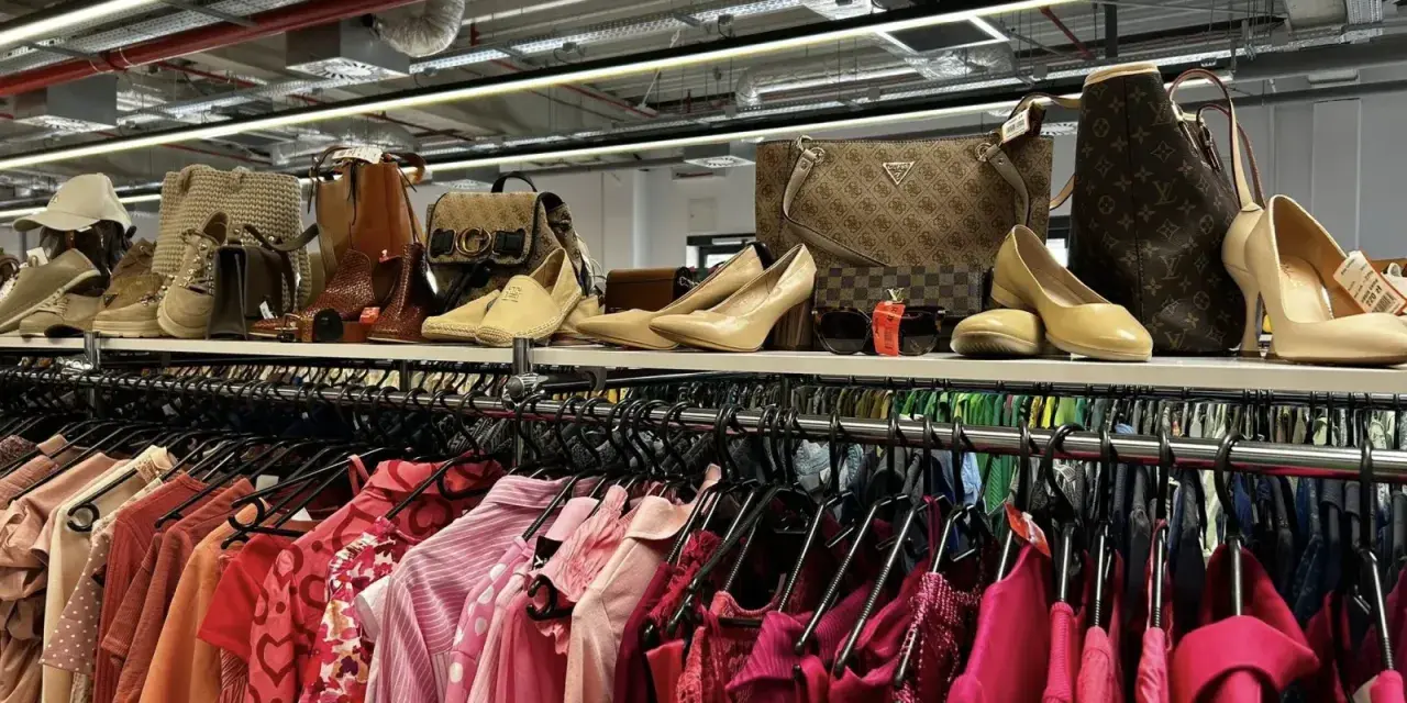 Na półce eleganckie buty i torebki, a poniżej rzędy różowych ubrań. Idealne miejsce, by znaleźć inspirację, jak szyc nowe kreacje.