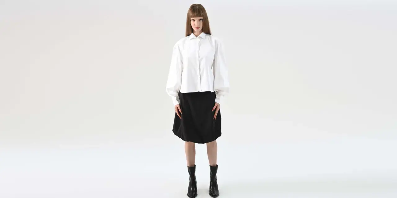 Elegancka stylizacja na maturę: biała koszula z bufiastymi rękawami i czarna spódnica.