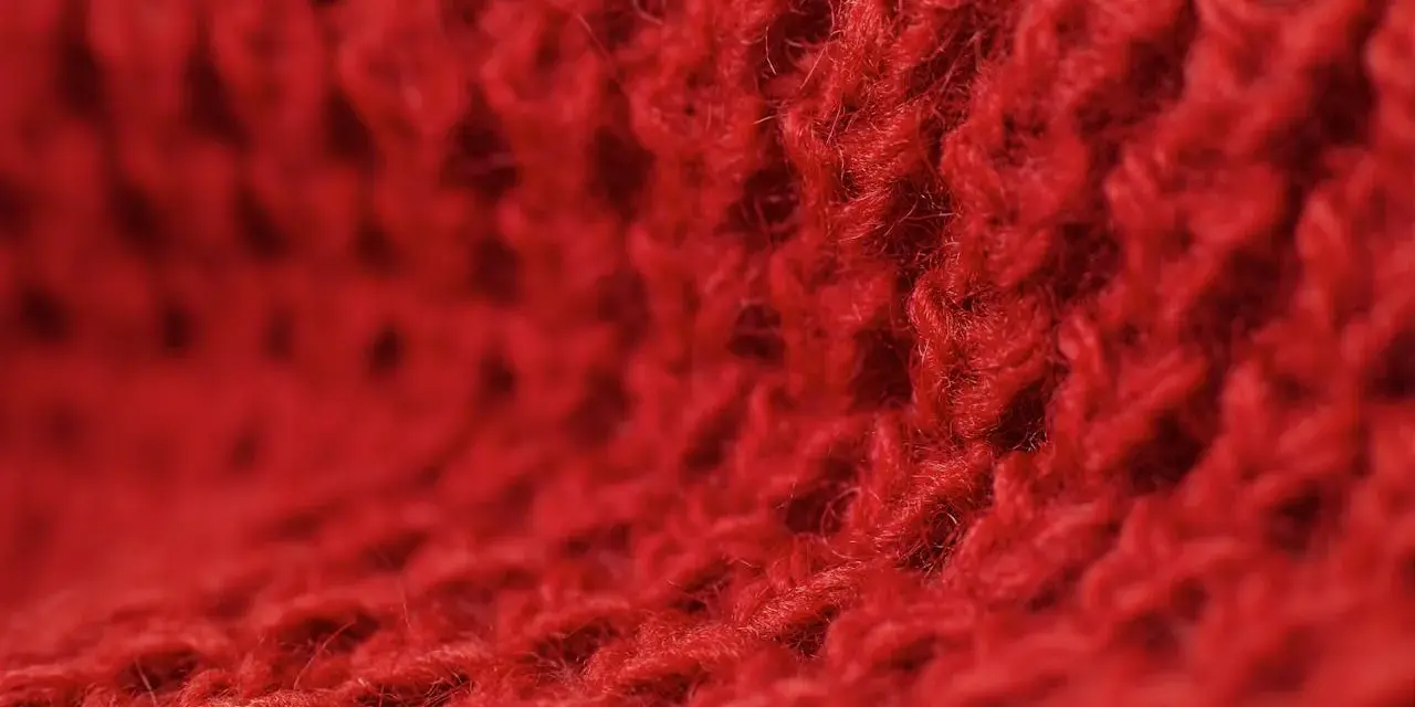 Czerwony, miękki materiał z widocznym splotem. Czy to angora? Co to jest angora? To delikatna wełna.