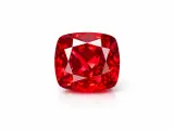 Czerwony, fasetowany **spinel** o szlifie brylantowym, odbijający światło.
