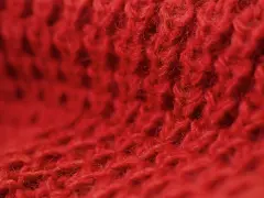 Czerwony, miękki materiał z widocznym splotem. Czy to angora? Co to jest angora? To delikatna wełna.