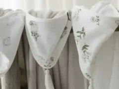 Trzy białe otulacze z muślinu, ozdobione delikatnymi wzorami zwierząt i kwiatów. Idealne dla maluszka, bo muślin co to? To lekka, oddychająca tkanina.