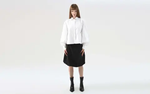 Elegancka stylizacja na maturę: biała koszula z bufiastymi rękawami i czarna spódnica.