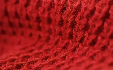 Czerwony, miękki materiał z widocznym splotem. Czy to angora? Co to jest angora? To delikatna wełna.
