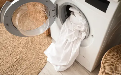 Białe pranie w pralce, gotowe do odświeżenia. Zastanawiasz się, co najlepiej przywraca biel ubraniom?