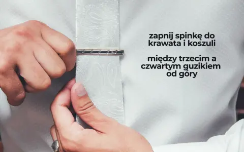 Mężczyzna zapina spinkę do krawata i koszuli między trzecim a czwartym guzikiem od góry. Elegancki sposób na noszenie krawata.