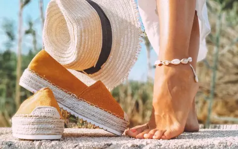 Letnie espadryle w kolorze musztardowym i słomkowy kapelusz. Dowiedz się, jak wyczyścić espadryle, by służyły Ci przez lata.