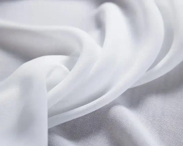 Delikatny, biały szyfon, co to za materiał? Lekki i zwiewny, idealny na letnie kreacje.