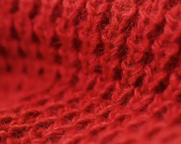 Czerwony, miękki materiał z widocznym splotem. Czy to angora? Co to jest angora? To delikatna wełna.