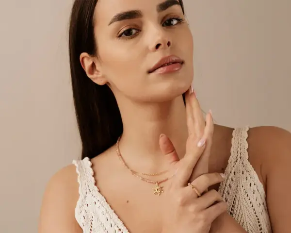 Delikatny naszyjnik z zawieszką w kształcie słońca, który pięknie podkreśla co oznacza choker na szyi.