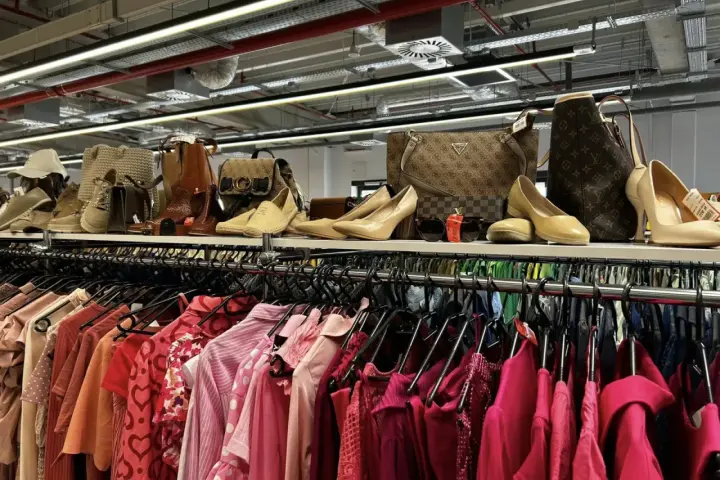Na półce eleganckie buty i torebki, a poniżej rzędy różowych ubrań. Idealne miejsce, by znaleźć inspirację, jak szyc nowe kreacje.