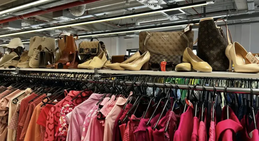 Na półce eleganckie buty i torebki, a poniżej rzędy różowych ubrań. Idealne miejsce, by znaleźć inspirację, jak szyc nowe kreacje.