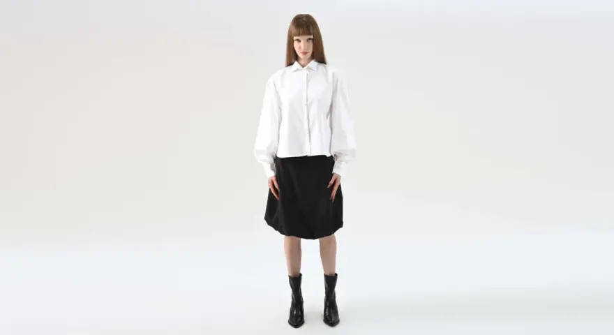 Elegancka stylizacja na maturę: biała koszula z bufiastymi rękawami i czarna spódnica.