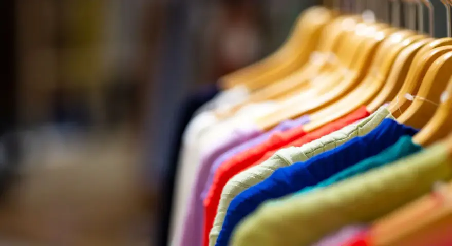 Kolorowe ubrania na wieszakach: fioletowy, czerwony, zielony, niebieski, turkusowy, żółty. Zastanawiasz się, jakie kolory można prać razem?