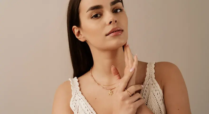 Delikatny naszyjnik z zawieszką w kształcie słońca, który pięknie podkreśla co oznacza choker na szyi.
