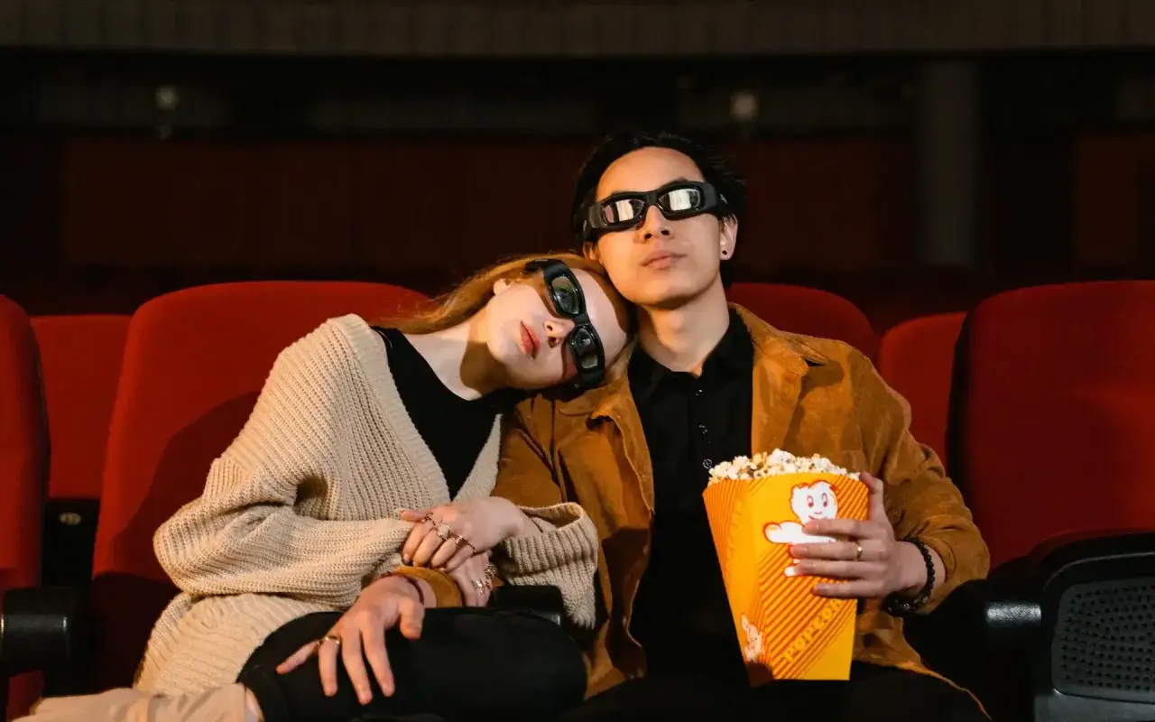 Para kino 3D, wygodny sweter i kurtka to idealny wyb&oacute;r. Para w okularach 3D z popcornem.